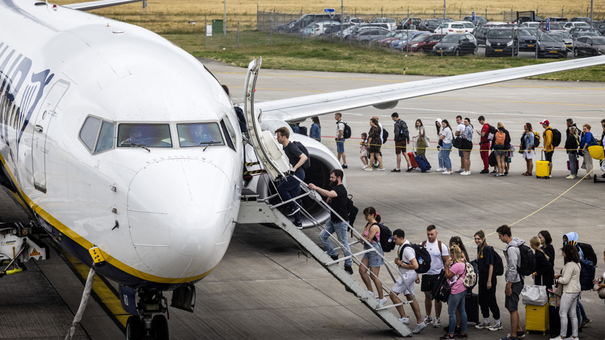 Reizigers boarden een vliegtuig van Ryanair op Eindhoven Airport in de zomervakantie. Foto: ANP.