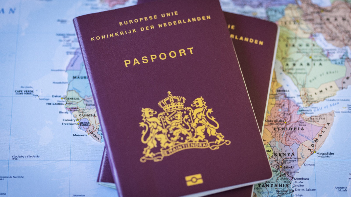 Twee Nederlandse paspoorten op een wereldkaart. Beeld: ANP.