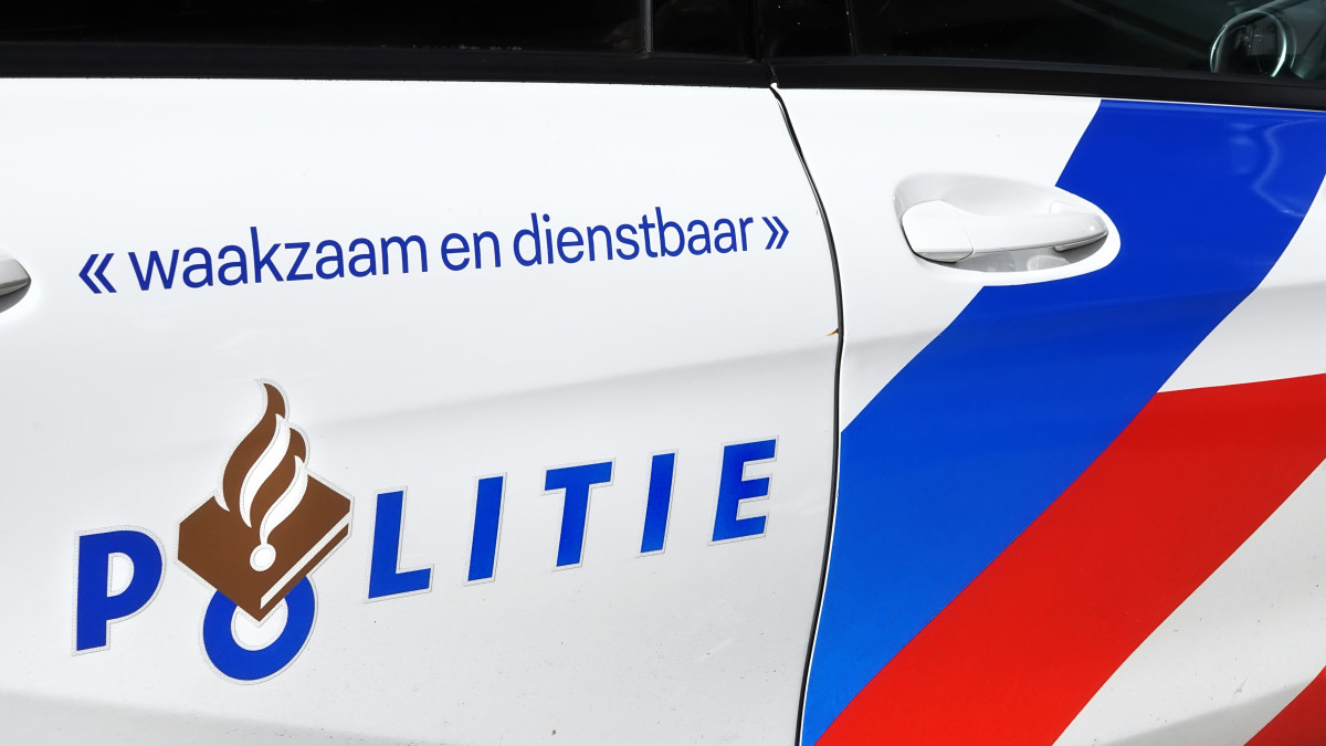 Het logo van de politie op de deur van een politieauto