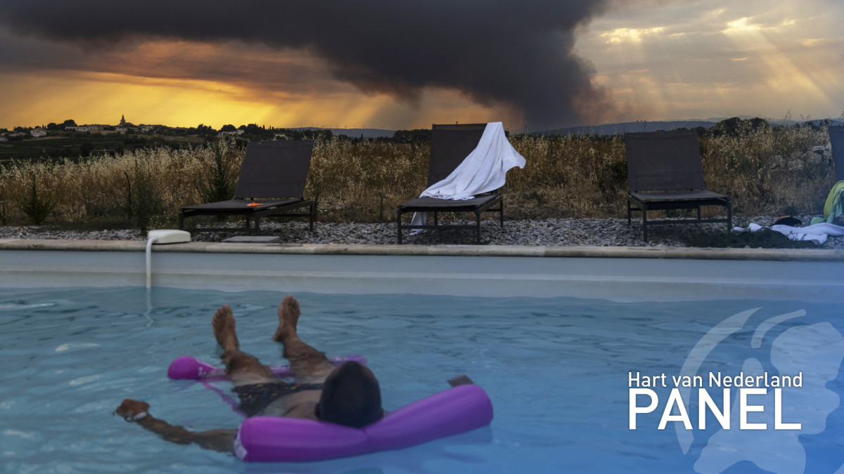 Foto: Man geniet in zwembad in Frankrijk, terwijl op achtergrond bosbrand woedt / ANP