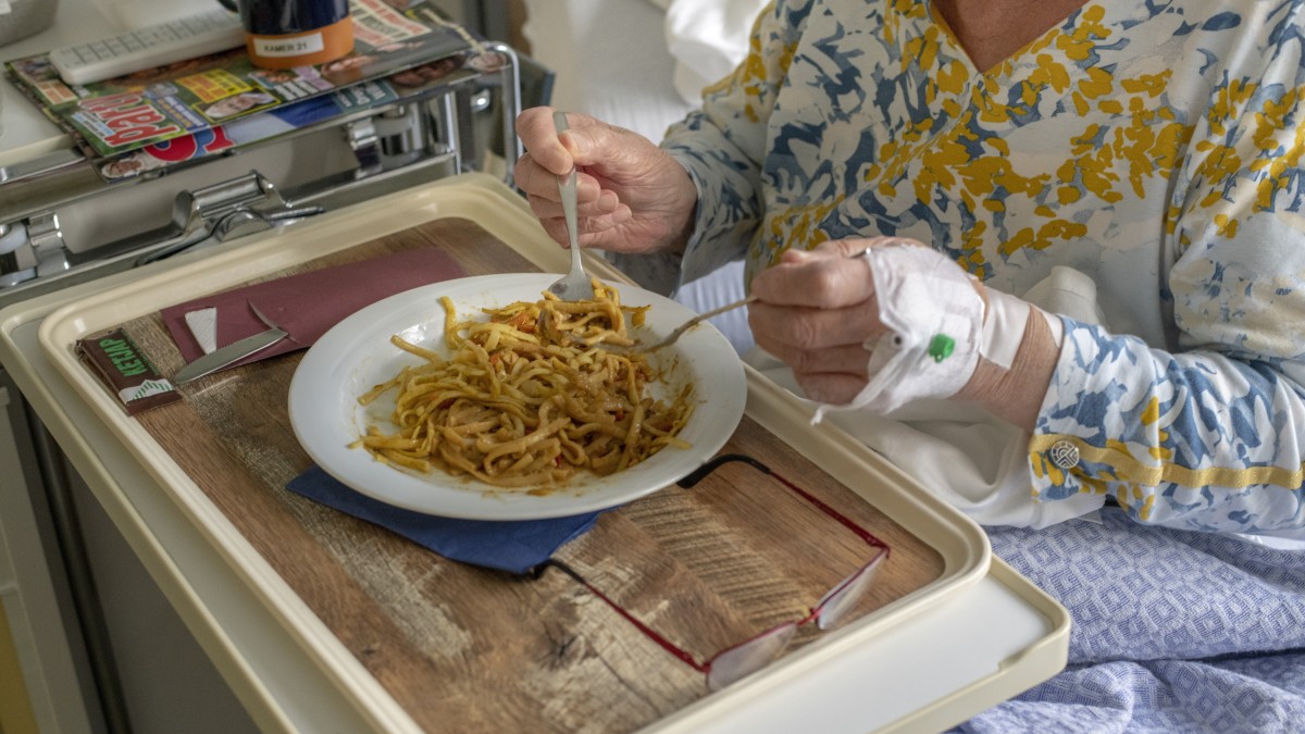 Een oudere dame eet een warme maaltijd in het ziekenhuis. Beeld: ANP.