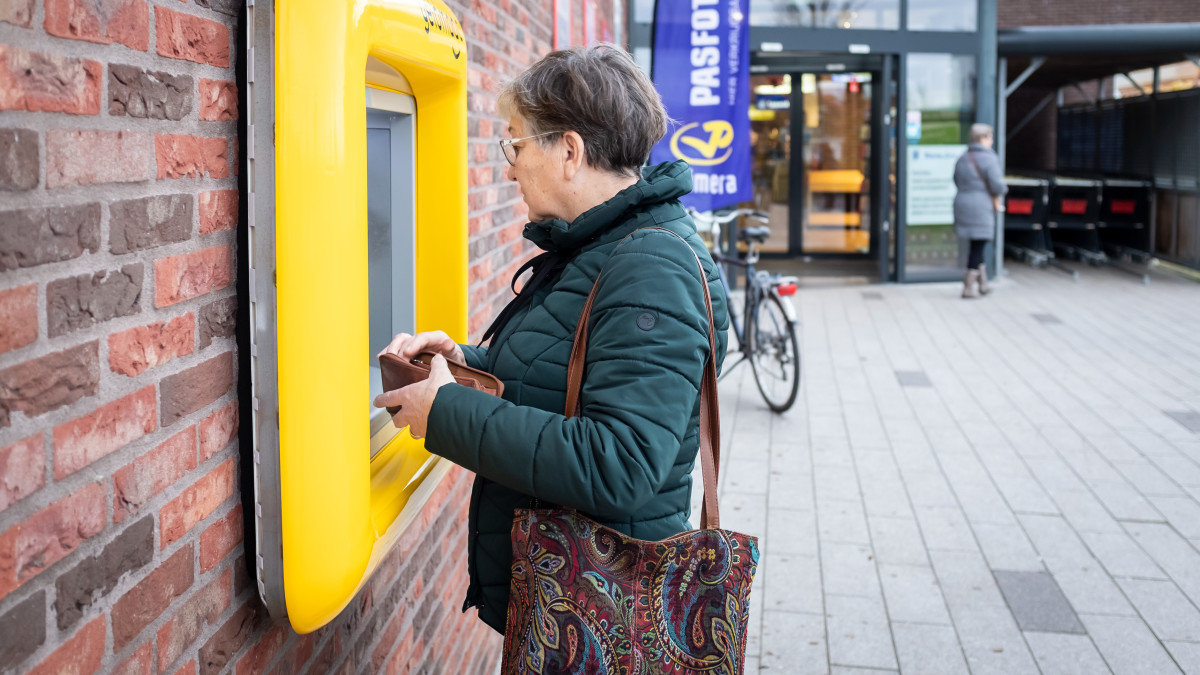 Vrouw pint geld bij geldautomaat van Geldmaat (ANP)