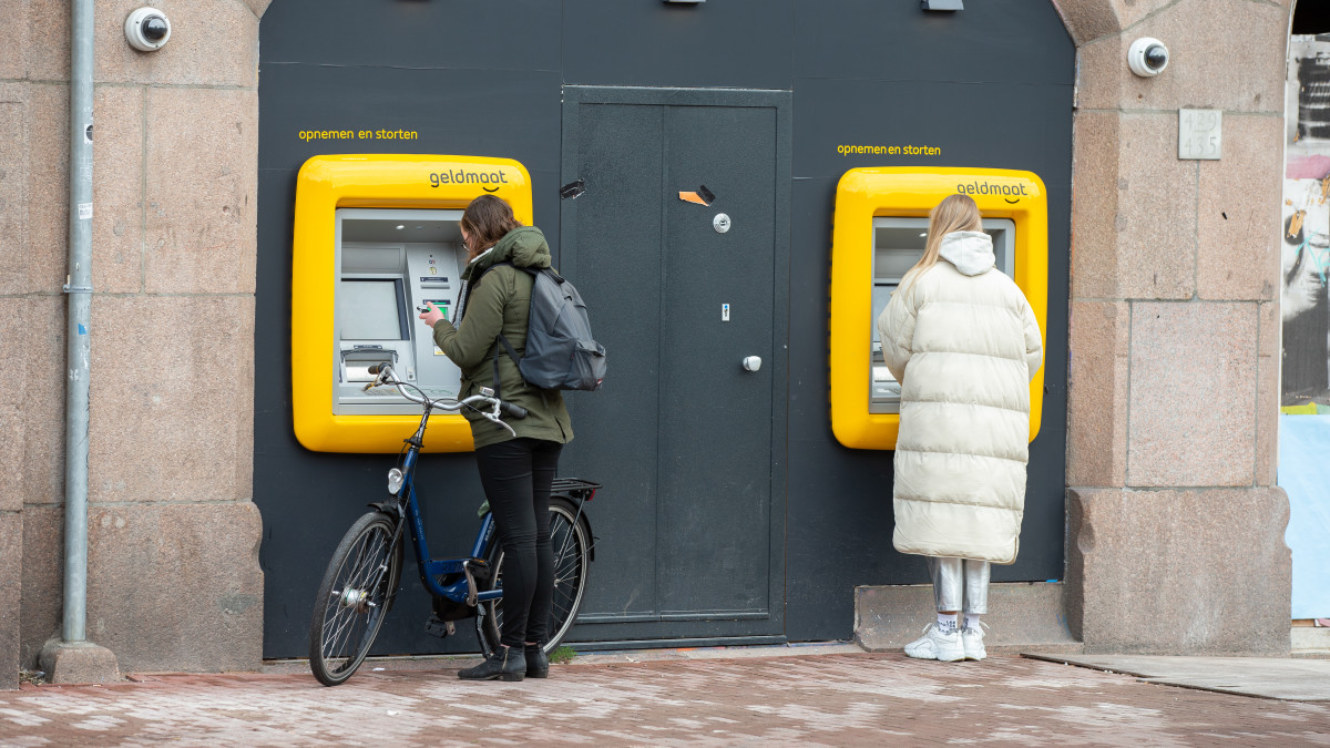 Mensen pinnen geld bij een geldautomaat van Geldmaat - Bron: ANP
