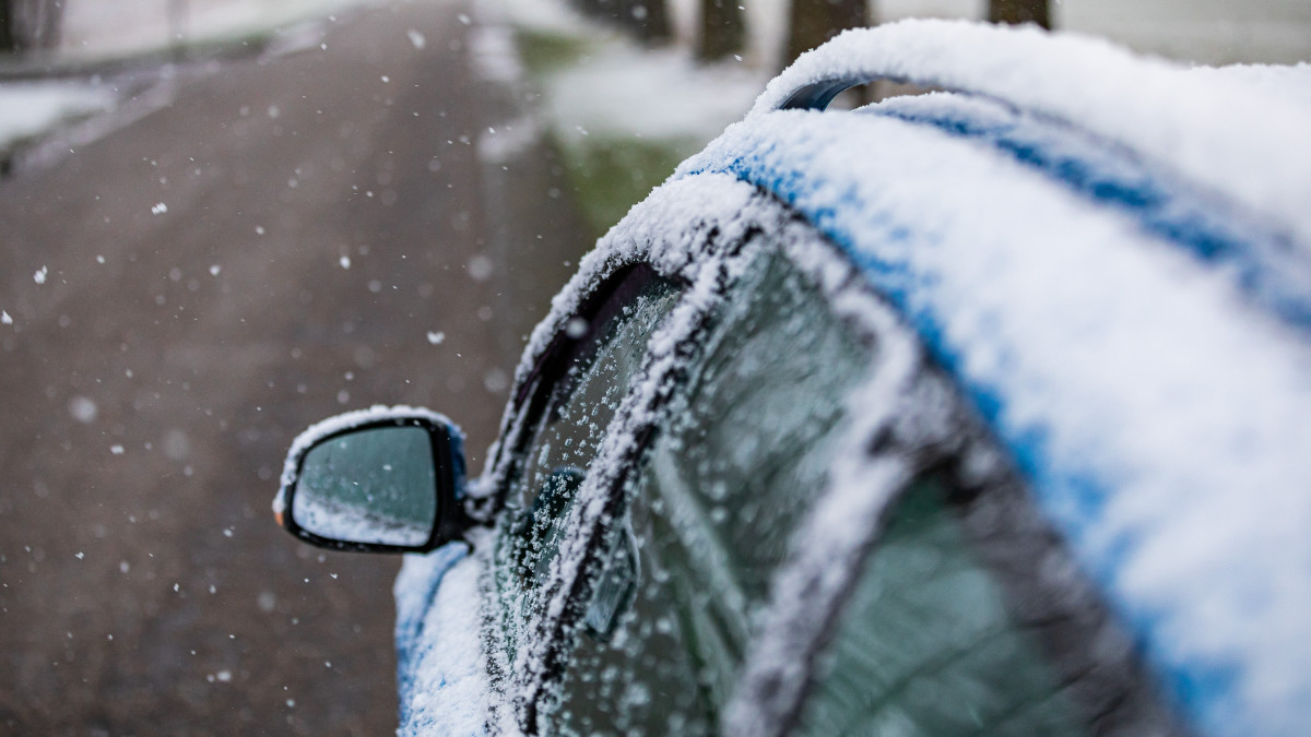 Een besneeuwde auto langs de weg. Zaterdag heeft het een groot deel dag gesneeuwd in Friesland. Beeld: ANP