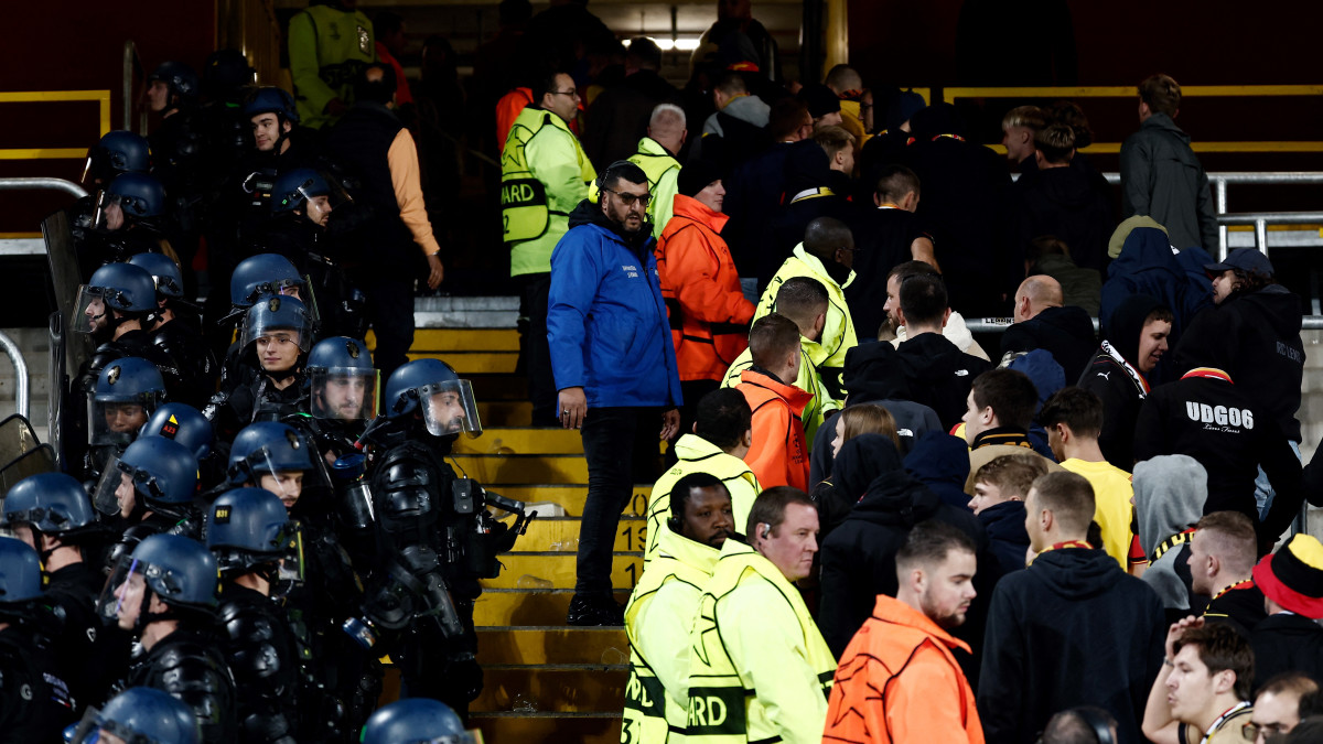 De politie en de stewards houden de twee groepen supporters uit elkaar in het Bollaert-Delelis stadium in Lens. Beeld: AFP